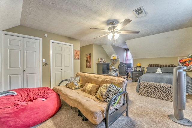 carpeted home office with baseboards, visible vents, a ceiling fan, and a textured ceiling
