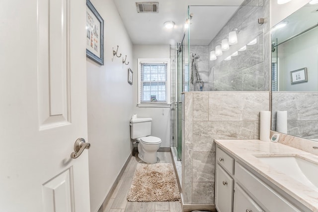bathroom with double vanity, wood finished floors, a jetted tub, and a sink