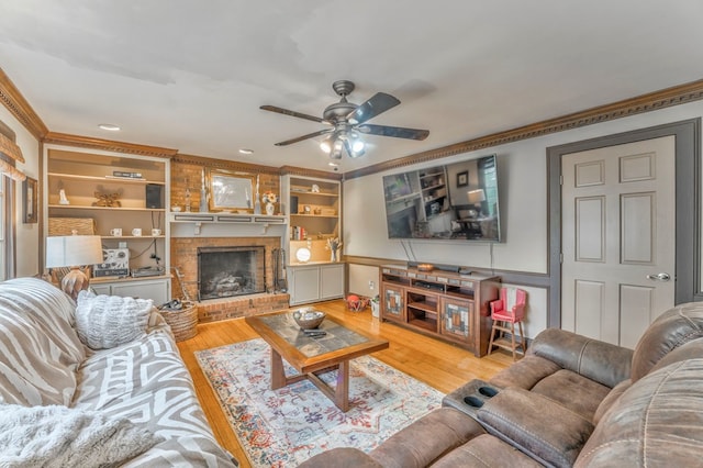 living area featuring ornamental molding, a fireplace, ceiling fan, and plenty of natural light