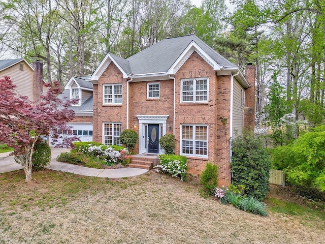 colonial home with an attached garage and brick siding