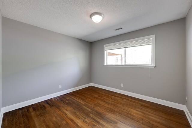 1113 Mount Vernon Rd, Tunnel Hill, GA 30755 - spare room with visible vents, a textured ceiling, baseboards, and dark wood-style floors