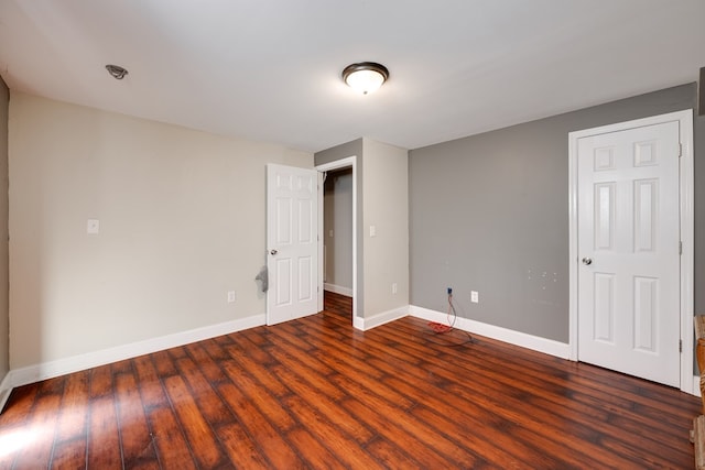 unfurnished bedroom with baseboards and wood finished floors