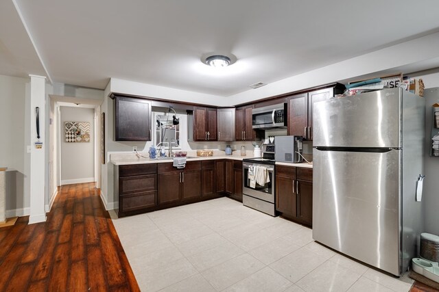 1113 Mount Vernon Rd, Tunnel Hill, GA 30755 - kitchen featuring dark brown cabinetry, appliances with stainless steel finishes, light countertops, baseboards, and a sink