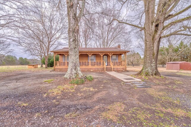 chalet / cabin with a porch and a chimney