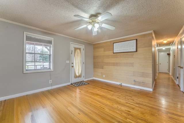 foyer entrance featuring a textured ceiling, light wood-style flooring, a ceiling fan, and ornamental molding