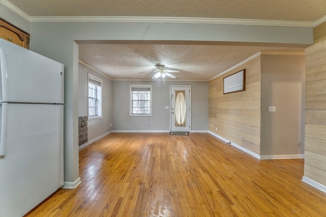 foyer with light wood finished floors, crown molding, baseboards, a textured ceiling, and a ceiling fan