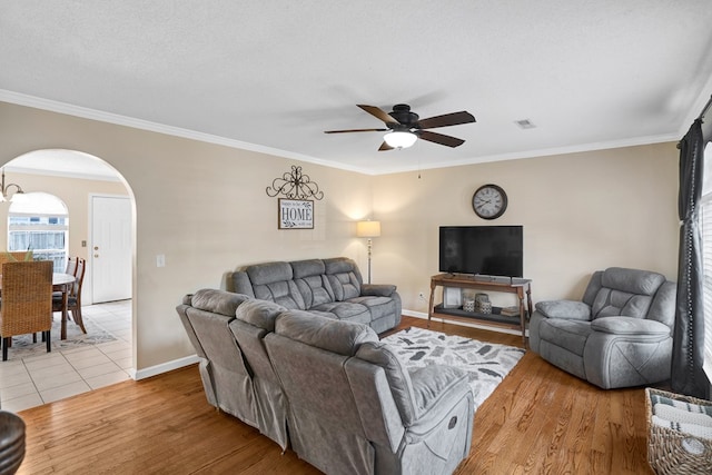 living room featuring crown molding, a textured ceiling, and light hardwood / wood-style floors