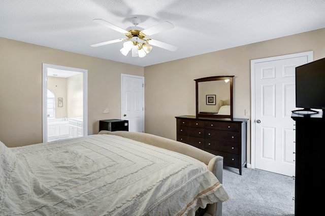 carpeted bedroom featuring ceiling fan and ensuite bath