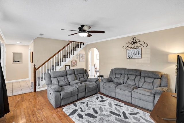 living room with ornamental molding, a textured ceiling, ceiling fan, and light wood-type flooring