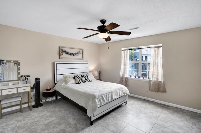 bedroom with ceiling fan and a textured ceiling