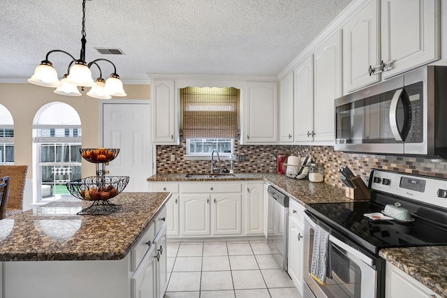 kitchen featuring tasteful backsplash, sink, white cabinets, a center island, and stainless steel appliances