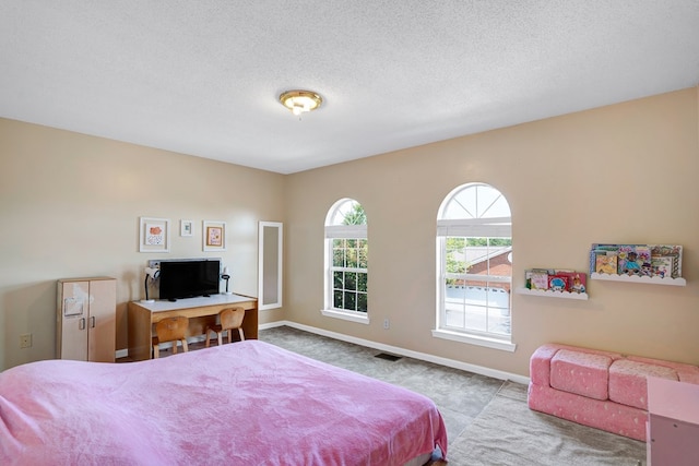 bedroom featuring light carpet and a textured ceiling