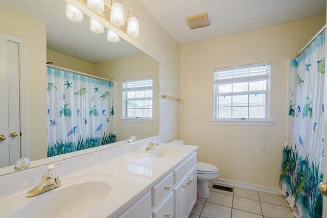 bathroom featuring vanity, plenty of natural light, tile patterned floors, and toilet