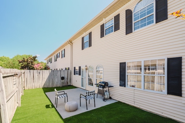 rear view of property with a patio and a lawn