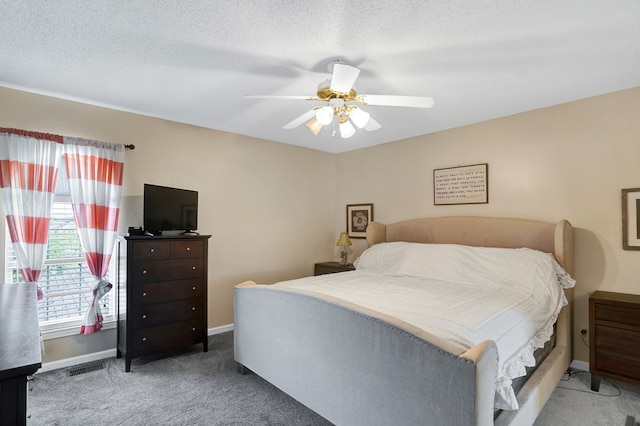 bedroom featuring ceiling fan, carpet, and a textured ceiling