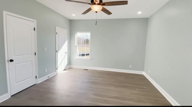 empty room featuring dark hardwood / wood-style flooring and ceiling fan