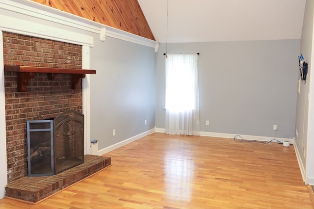 unfurnished living room featuring vaulted ceiling, a fireplace, and light hardwood / wood-style floors