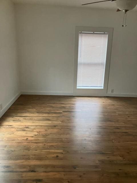 spare room featuring dark wood-type flooring and ceiling fan