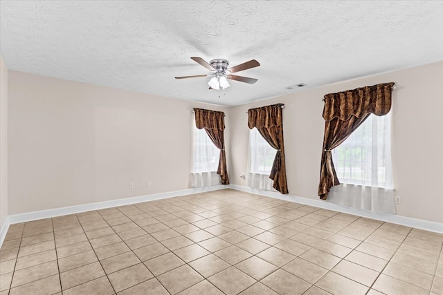 tiled spare room featuring a textured ceiling and ceiling fan