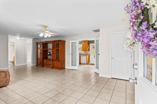 empty room with light tile patterned floors, a textured ceiling, and ceiling fan