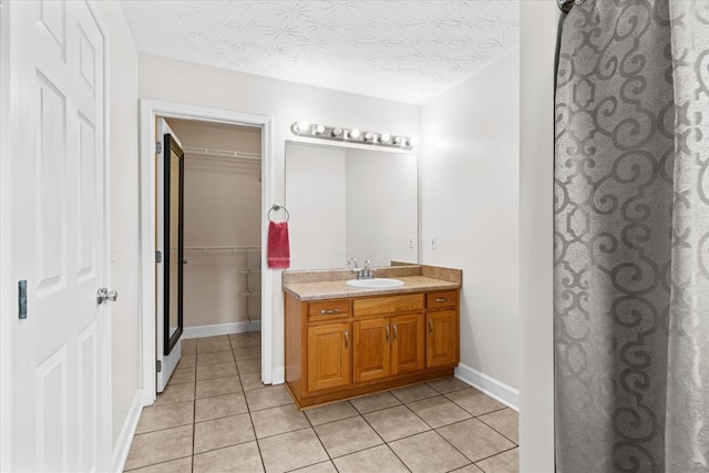 bathroom with tile patterned floors, vanity, and a textured ceiling