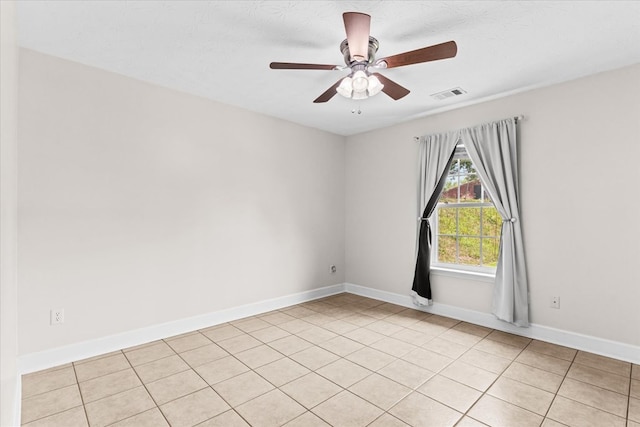 tiled spare room featuring a textured ceiling and ceiling fan