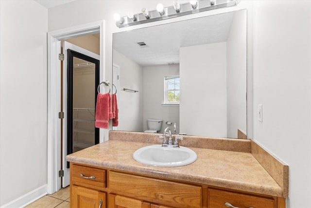 bathroom with vanity, tile patterned floors, and toilet