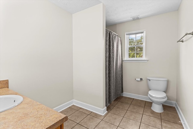 bathroom with vanity, toilet, tile patterned flooring, and a textured ceiling