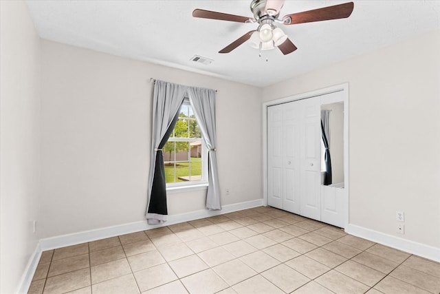 empty room with ceiling fan and light tile patterned flooring