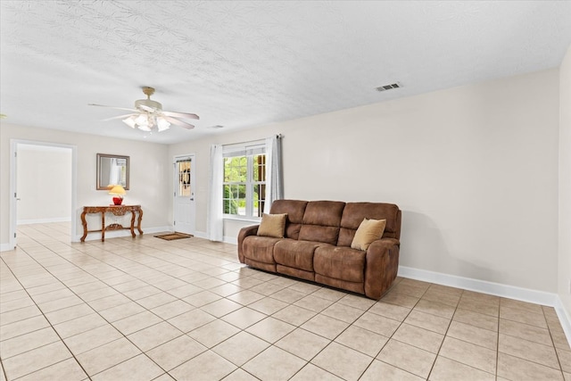 living room with light tile patterned floors, a textured ceiling, and ceiling fan