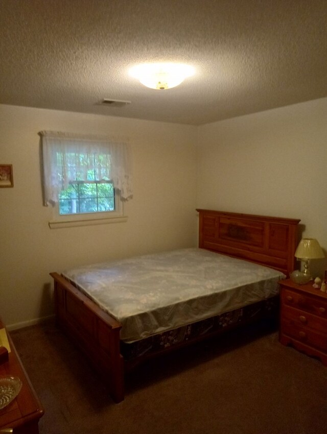 carpeted bedroom with a textured ceiling