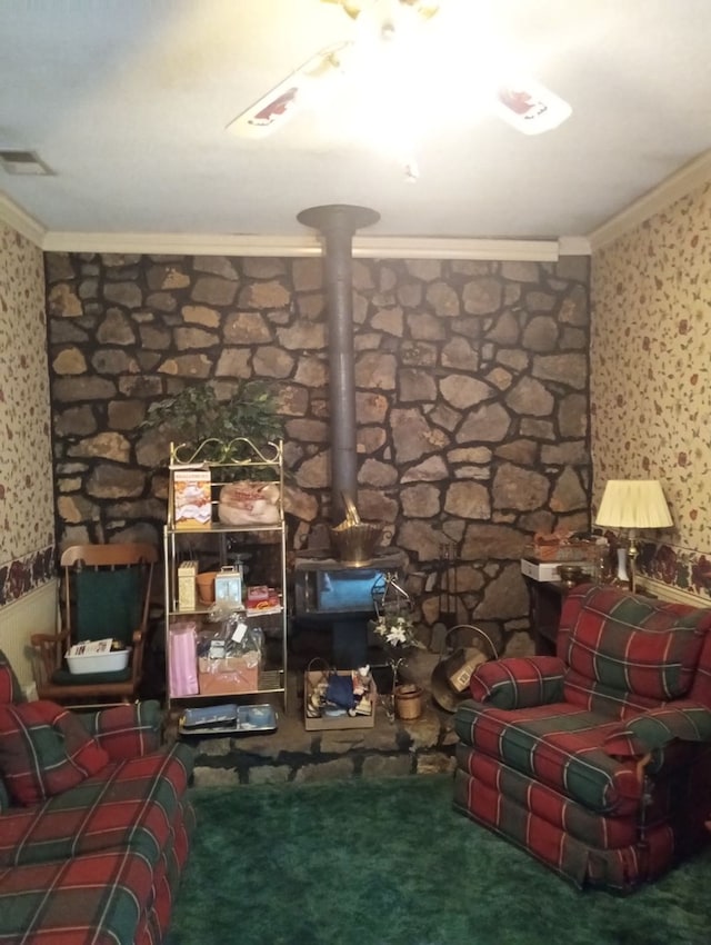 sitting room with crown molding, a wood stove, and carpet flooring