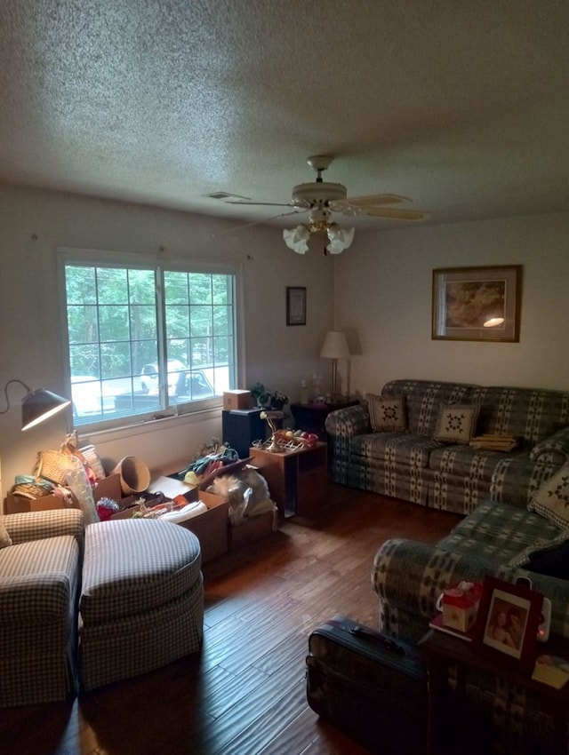 living room with ceiling fan, hardwood / wood-style flooring, and a textured ceiling