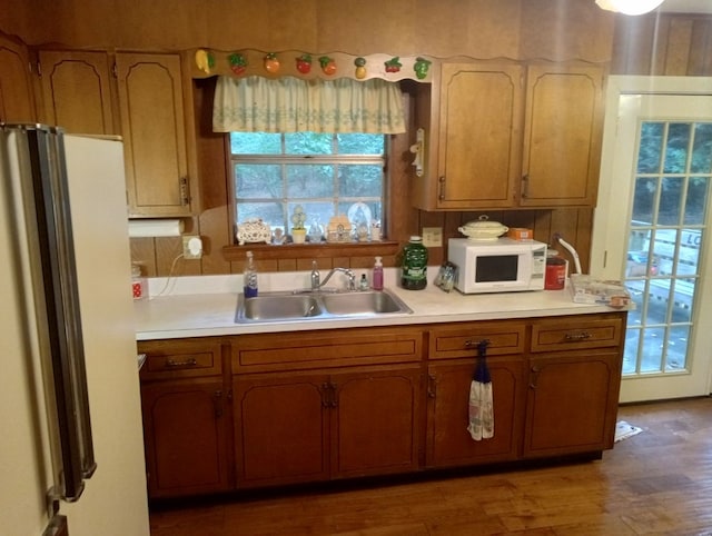 kitchen with sink, hardwood / wood-style flooring, and fridge