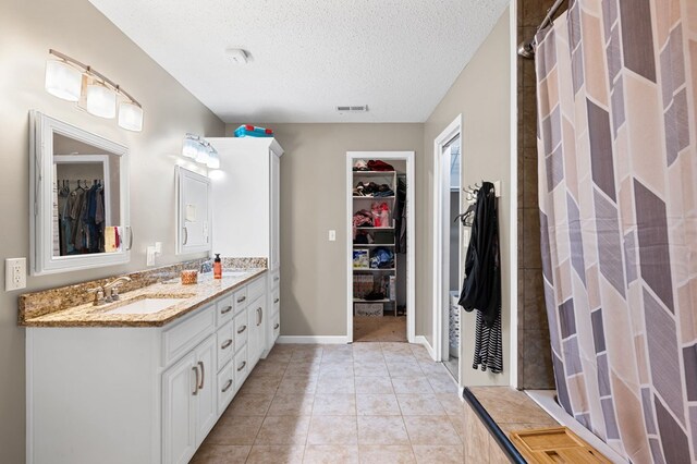 3414 Chattanooga Rd, Tunnel Hill, GA 30755 - full bathroom featuring double vanity, a walk in closet, a textured ceiling, curtained shower, and tile patterned floors