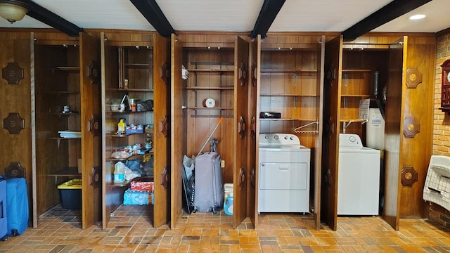 laundry area featuring wood walls, laundry area, heating unit, brick floor, and washer and clothes dryer