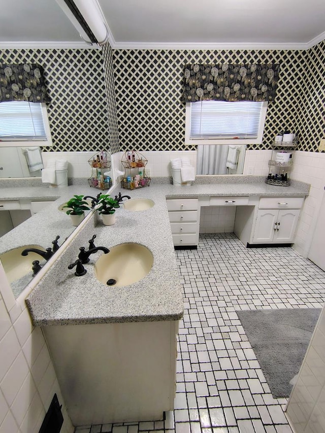 bathroom featuring tile walls, ornamental molding, and a sink
