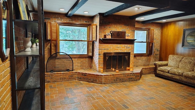 living area featuring beam ceiling, a brick fireplace, brick floor, and recessed lighting