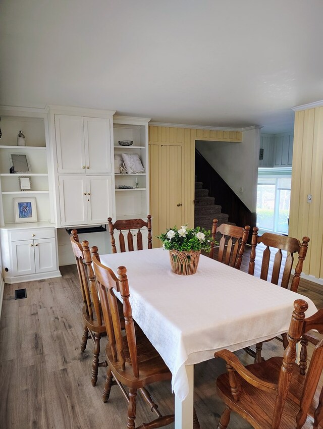 dining area with light wood-style floors, visible vents, and stairway