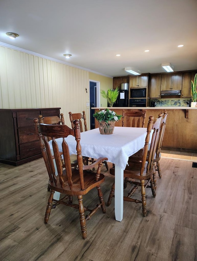 dining space featuring crown molding, light wood-style floors, and recessed lighting