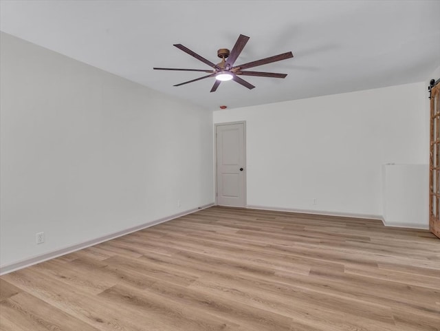100 Tibbs Rd, Dalton, GA 30720 - spare room with a barn door, ceiling fan, and light wood-style floors