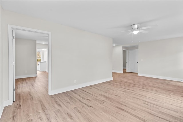 unfurnished room with light wood-style floors, baseboards, and a ceiling fan