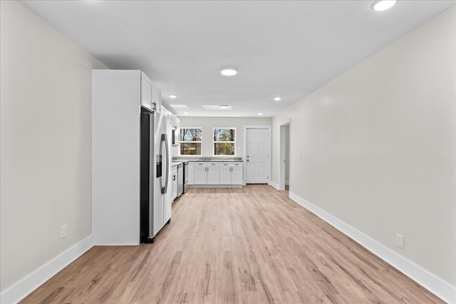 kitchen featuring baseboards, light wood-style floors, light countertops, white cabinets, and stainless steel fridge with ice dispenser