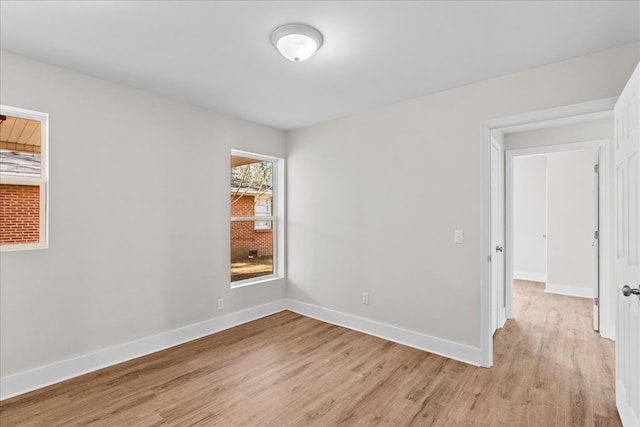 empty room with light wood-type flooring and baseboards