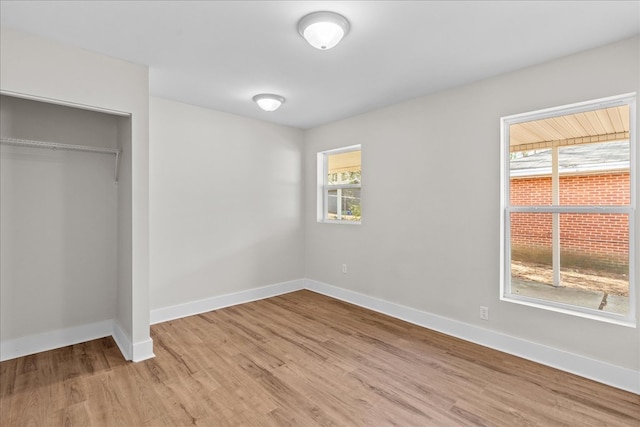 unfurnished bedroom featuring a closet, baseboards, and wood finished floors