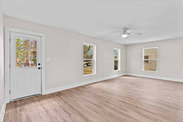 interior space with light wood finished floors, baseboards, and a ceiling fan