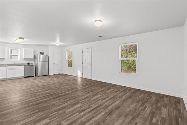 unfurnished living room featuring sink and dark wood-type flooring