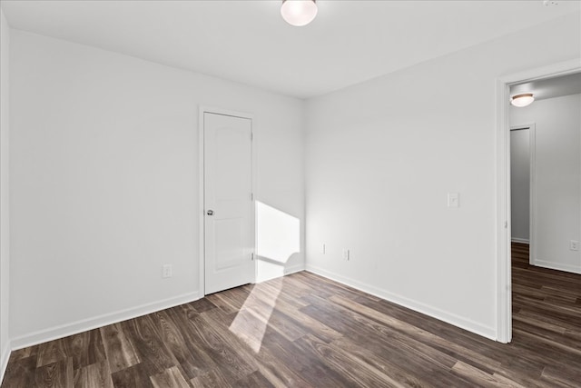 unfurnished room with dark hardwood / wood-style flooring