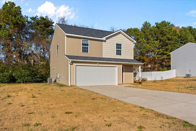 view of front of property featuring a garage, a front yard, and central AC unit