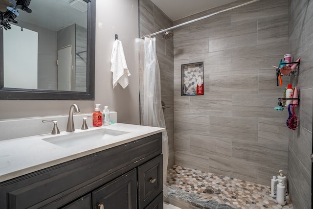 full bathroom with tiled shower and vanity